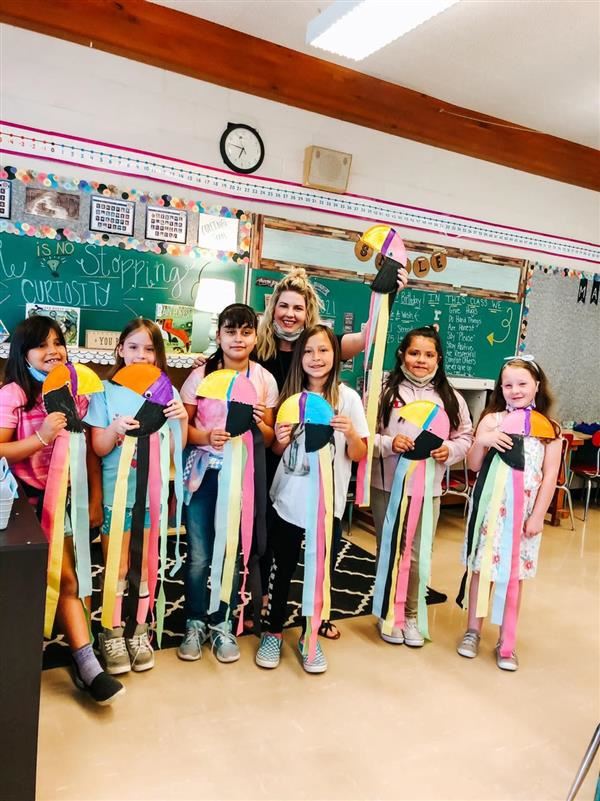 West kids holding up artwork they made